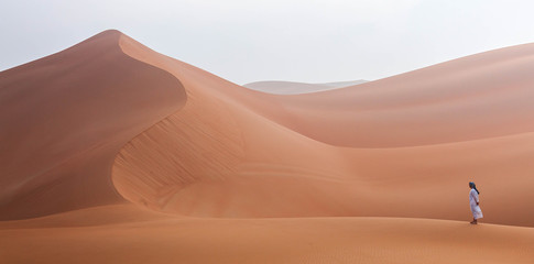 Emirati man walking in the empty quarter desert