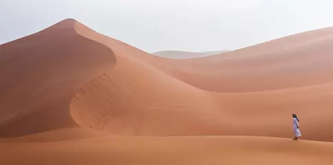 Foto op Plexiglas Emirati man walking in the empty quarter desert © SELIMBT