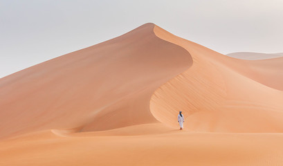 Fototapeta na wymiar Emirati man walking in the empty quarter desert