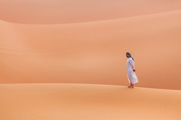 Fototapeta na wymiar Emirati man walking in the empty quarter desert