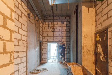Drywall installation work in progress by construction workers at construction room. Construction...