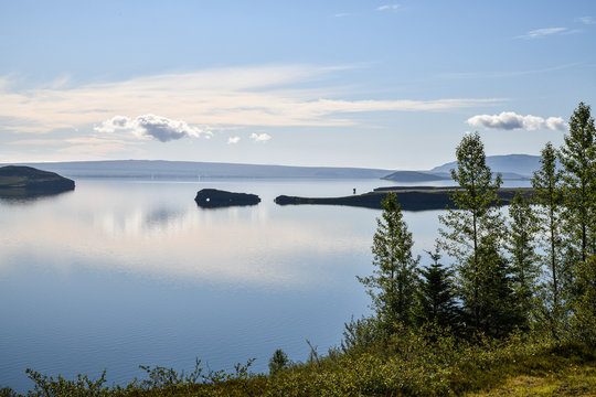 Islands spiegelglatte Seen mit Bergen im Hintergrund und blauem Himmel mit Wolken