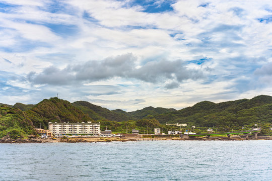 Coast of the Kanaya Marina along the Uraga Channel with the loop ramp of the Futtsu Kanaya Interchange in front of the Mount Nokogiri in the Bōsō Peninsula.
