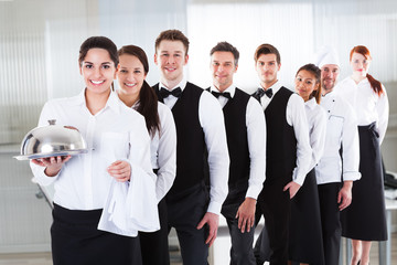 Large group of waiters and witresses standing in row