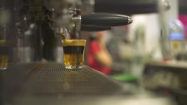 M&aacute;quina de caf&eacute; llenando una taza con humeante caf&eacute;