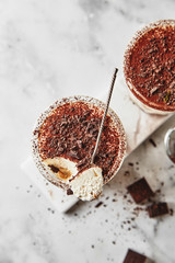 Portion dessert tiramisu in a glass on a marble background