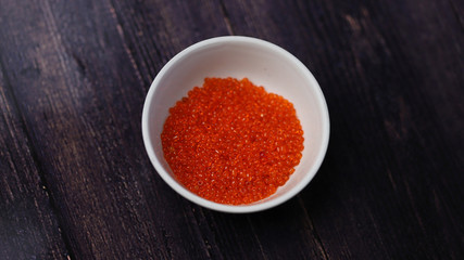 Red beads in white cup on black background