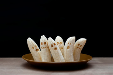 Homemade Halloween scary banana ghosts monsters with chocolate faces. Funny dessert for Halloween...