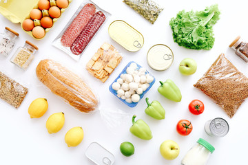 Set of grocery items from canned food, vegetables, cereal on white background. Food delivery concept. Donation concept. Top view.