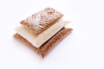 Set of transparent bags with rice, lentils, buckwheat grain on white background