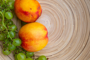 Peach and grapes on bamboo plate