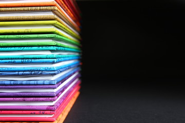 Stack of colorful books on black background