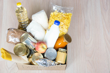 Food donations. canned food, pasta and cereals cardboard box. or food delivery concept.