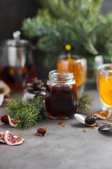 Pine cone jam in a small open jar among pine branches. Tea party with sweets.