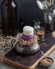 Multicolored macarons on the table with wooden accessories. Vintage cups.