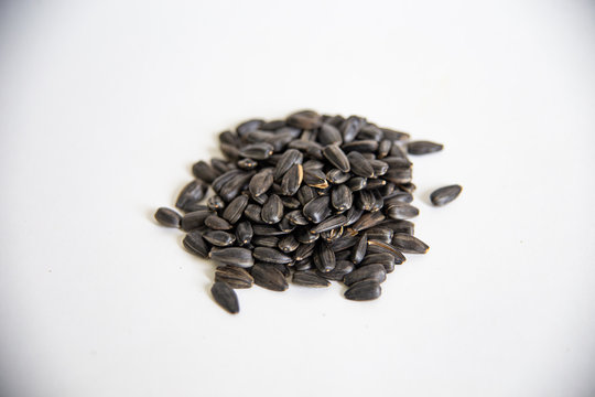 a bunch of black sunflower seeds on a white background