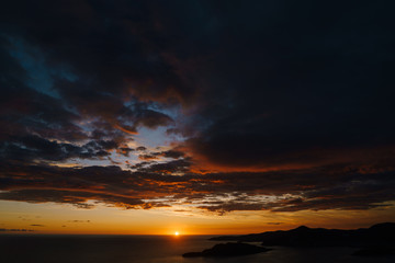 Fiery golden sunset in Montenegro over the sea. Near Sveti Stefan and the island of St. Nicholas, on the Budva Riviera.