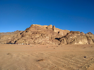 Textured sand mountains in Wadi Rum desert in Jordan. Clear blue sky. Theme of travel and safari in Jordan.