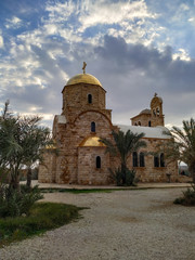 Fototapeta na wymiar View of St. John the Baptist Greek Orthodox Church, located at the site of the baptism of Jesus Christ on the Jordan River. Blue sky with some clouds.