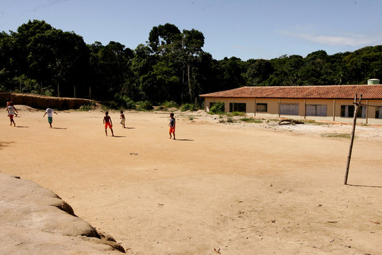 porto seguro, bahia / brazil - july 23, 2010: children are seen playing football in a clay cambo in the city of Porto Seguro.