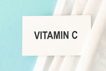 Word vitamin c with medical mask on a blue background.