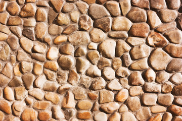 antique wall from brown small rounded stones.