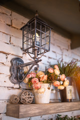 artificial flowers and a flashlight on the front of a brick wall in the interior
