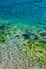 Blue sea water with stones in moss.