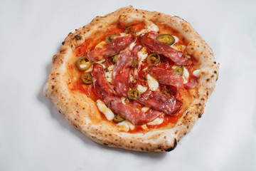 Italian pizza with pepper and jamon on a white background.