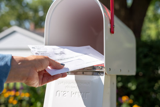 Barrington, IL/USA - 08/22/2020:  Woman taking applications for mail in voting out of home mailbox