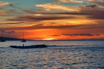 Surfer at sunset over the sea in Lahaina on Maui.