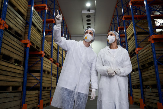 Warehouse Employee And A Female Manager Staring Upward