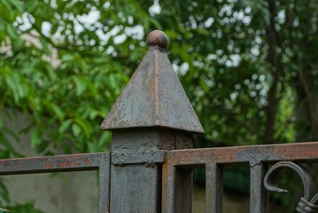 part of an  iron decorative fence with a sharp one detail with a tip of gray metal