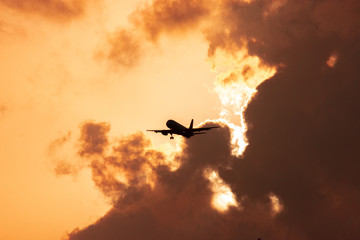 Plane flying low against light.