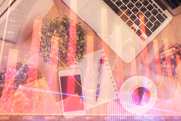 Fototapeta premium Multi exposure of financial chart hologram over desktop with phone. Top view. Mobile trade platform concept.