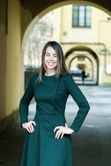 A long-haired girl in a green dress walks through the shabby courtyards of the old city