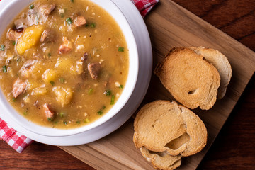 .Cassava broth. Creamy broth made with cassava, sausage, bacon and meat. .Accompanied by toast Top view Top view