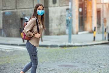 Girl going to school with protective mask. Woman on school campus. Mask for COVID-19. Back to...