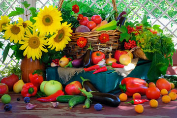 Still life of vegetables, fruits, herbs and flowers on a wooden table in the gazebo. Summer still...