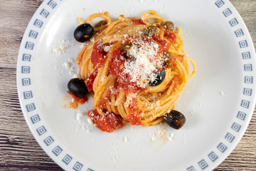 Spaghetti alla Puttanesca, with tomato, olives, capers and anchovies.
