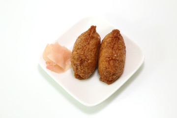 白い皿にのったいなり寿司とガリ