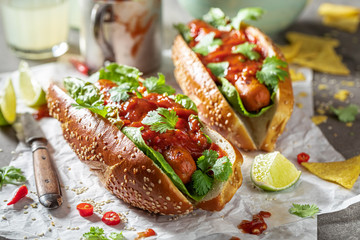Delicious barbecue hot dogs with red sauce and coriander