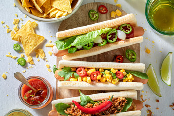 Tasty hot dogs with vegetables, herbs and sauce