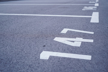 Close-up of white paint markings on parking lot.Empty car parking, Car parking lot with white mark, Parking lane outdoor in public park.Selective focus