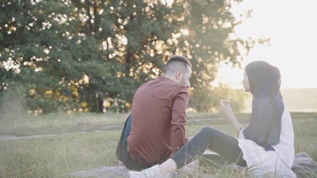 Muslim Couple Drinks From Turkish Cup Of Tea Named Armudu And Eats Pizza And Have Fun. Love Story Of Mixed Couple. Romantic Dinner In Nature According To Self-isolation Rules