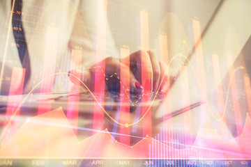 Double exposure of businesswoman hands typing on computer and financial graph hologram drawing. Stock market analysis concept.