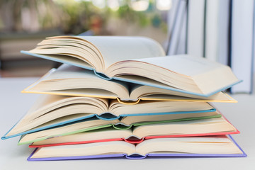 Close up, Desk with stack of open study books. Textbooks for the student, university. Study from home. Distance education concept.