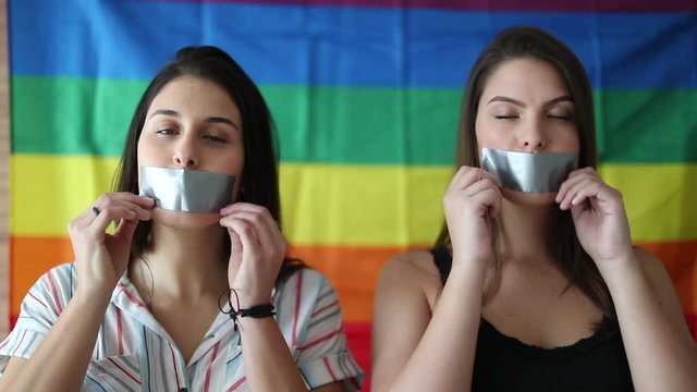Two women removing mouth tape. LGBT concept