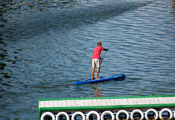 Boy swims on a sap board on the lake
