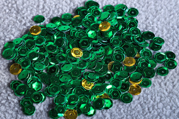 Green and gold sequins on grey background